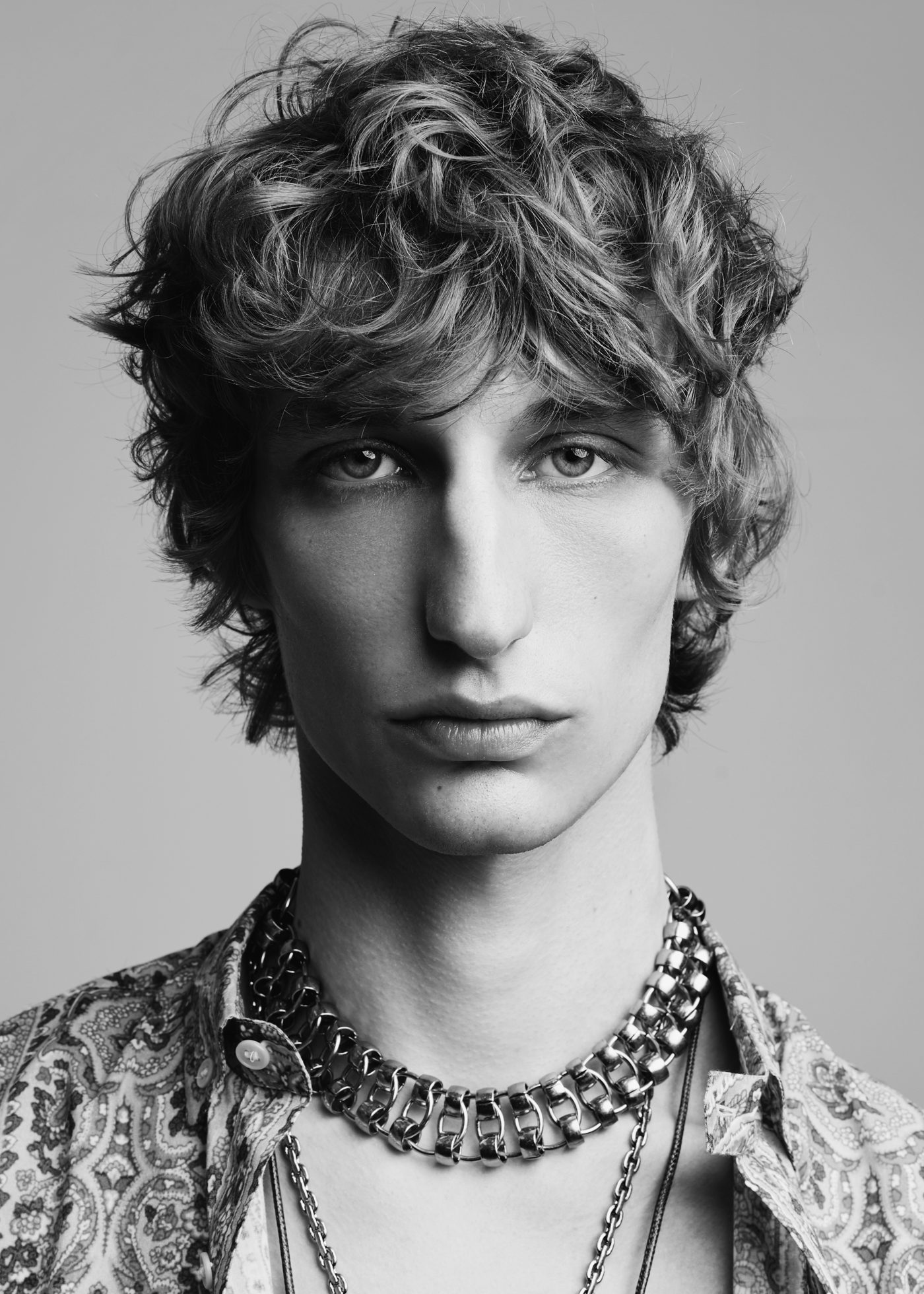 Model with textured, curly shag cut and fringe — black and white portrait